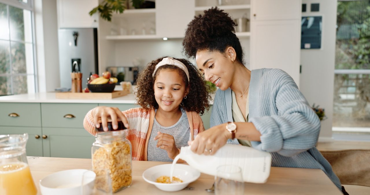 mother child and breakfast cereal in morning for healthy nutrition with calcium milk preparing or